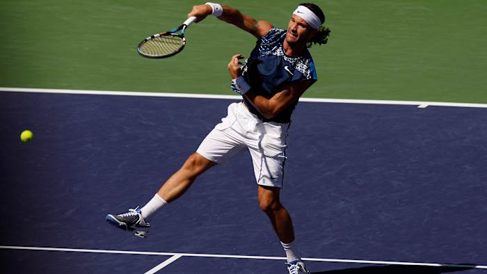 Carlos Moya returns a shot against James Blake.